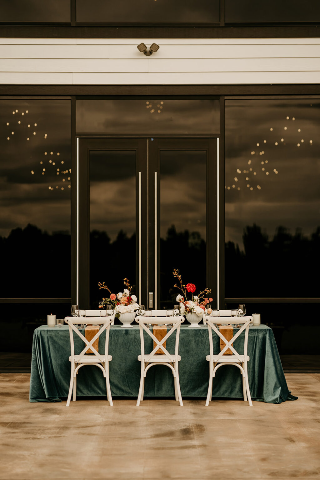 A table with four chairs and a green tablecloth.