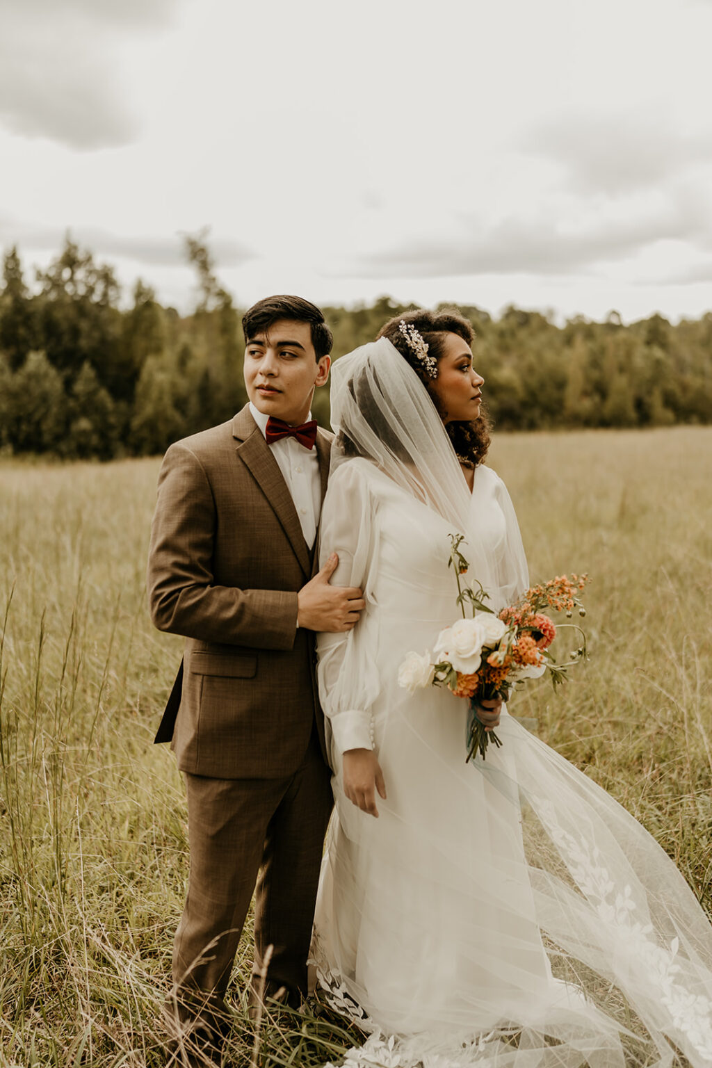 A man and woman standing in the middle of a field.