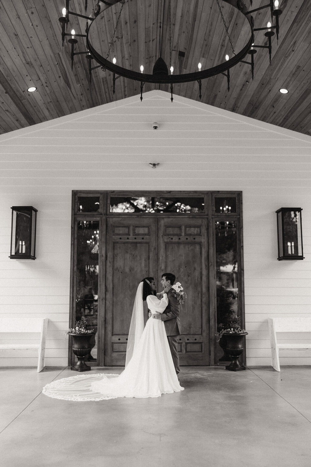 A bride and groom kissing in front of the door.