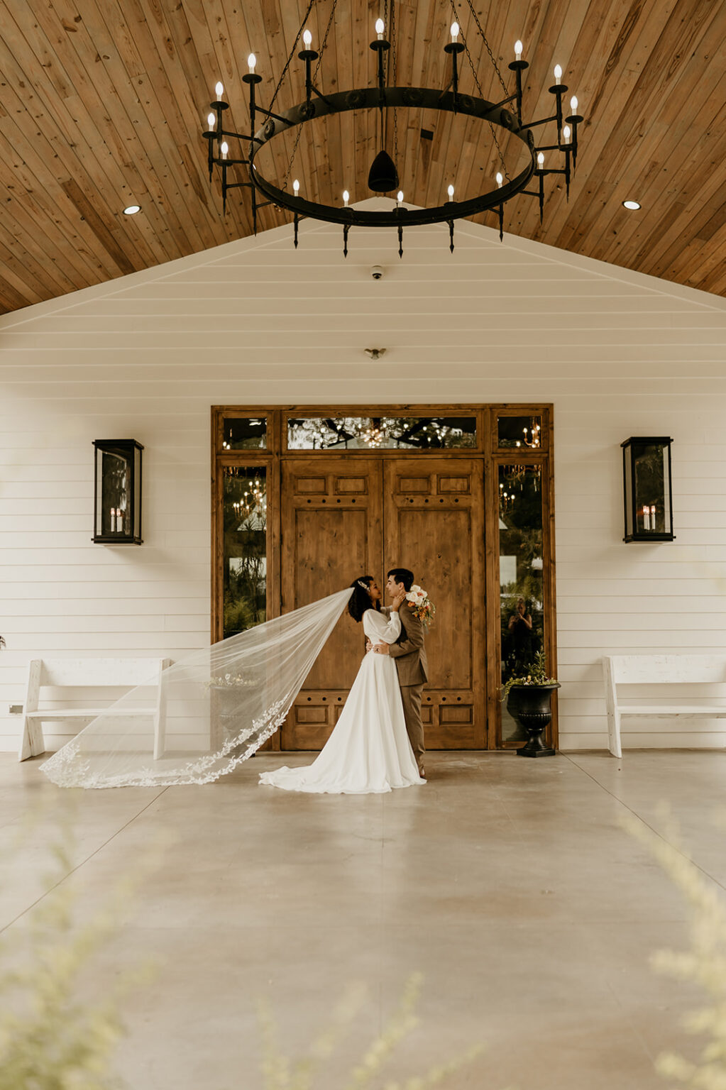 A bride and groom kissing in front of the church.