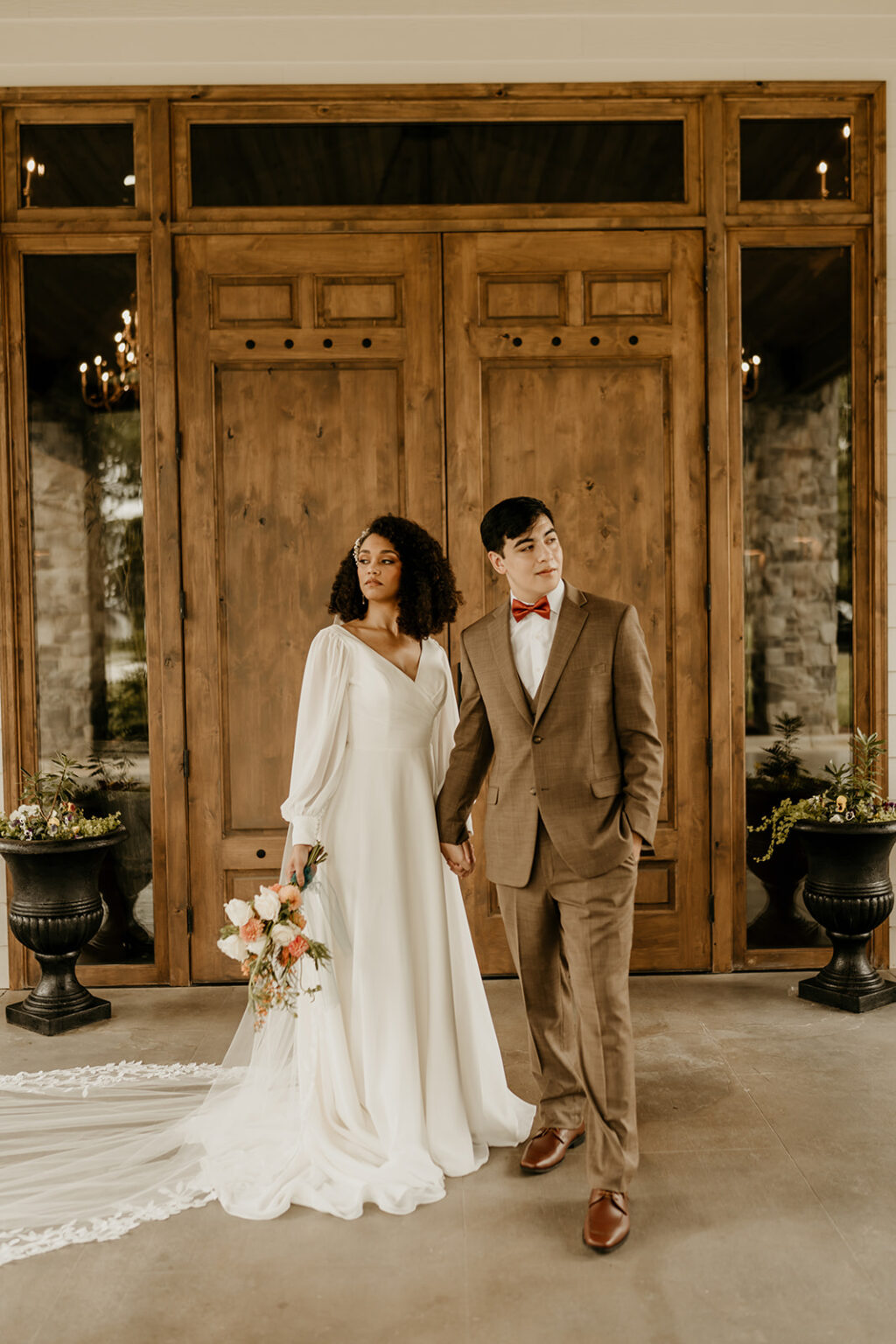 A man and woman holding hands in front of a door.