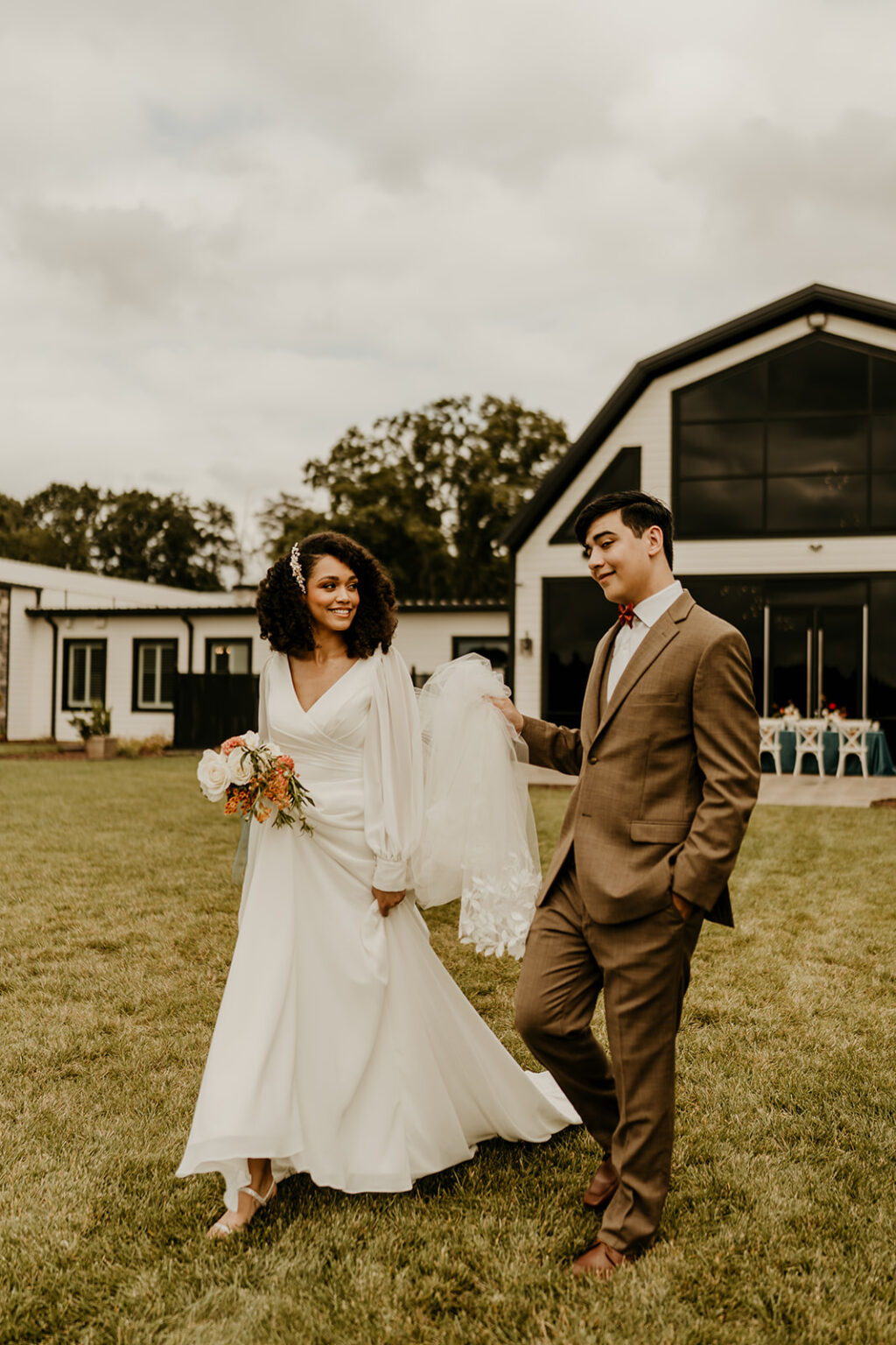 A man and woman walking in front of a barn.