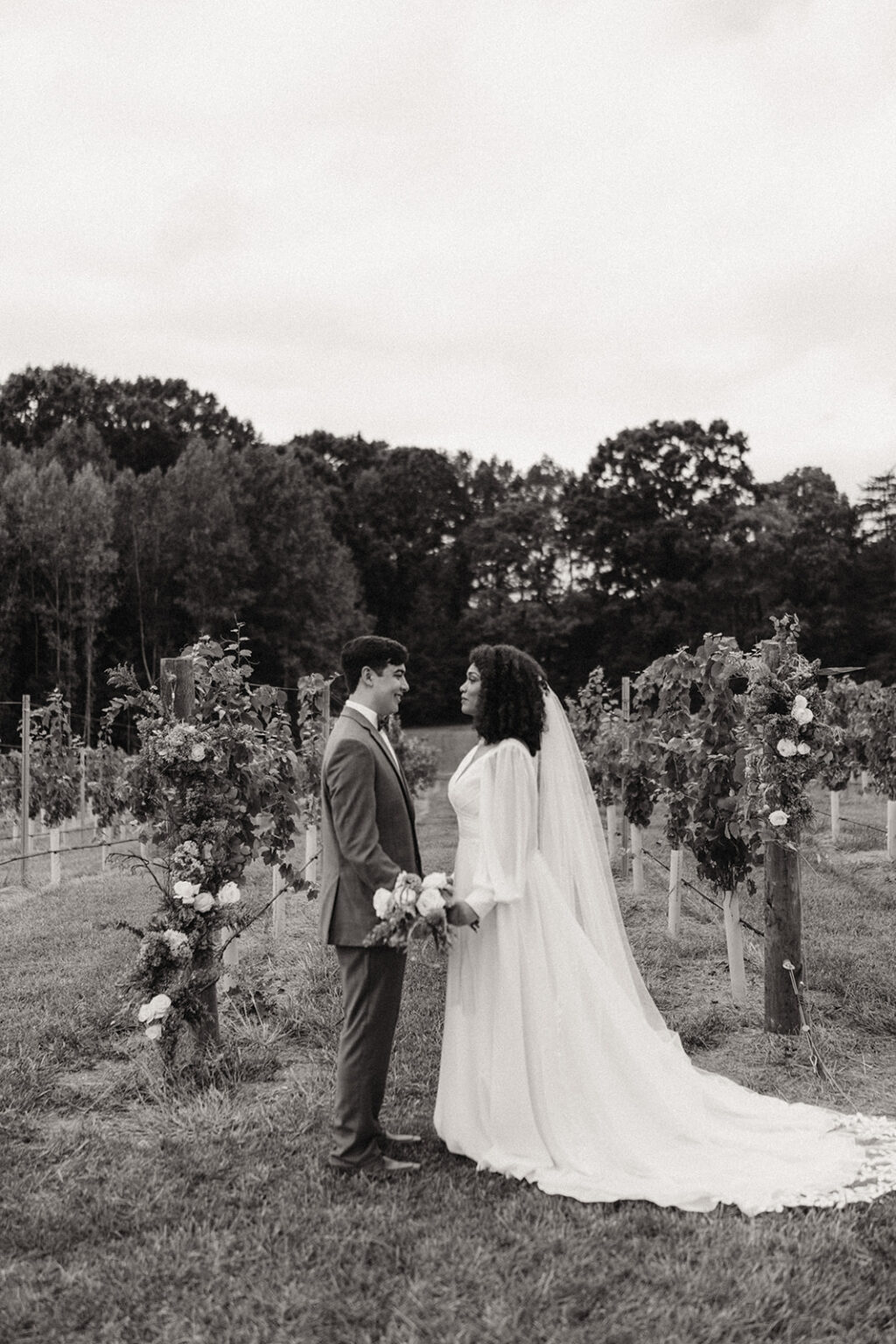 A bride and groom standing in front of some trees