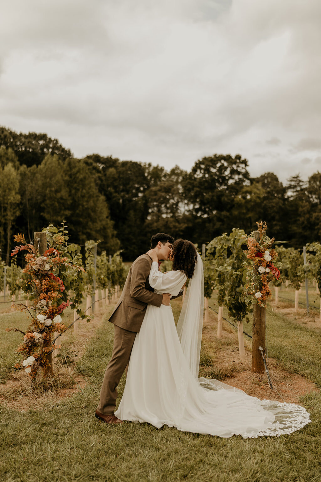 A couple kissing in front of some trees