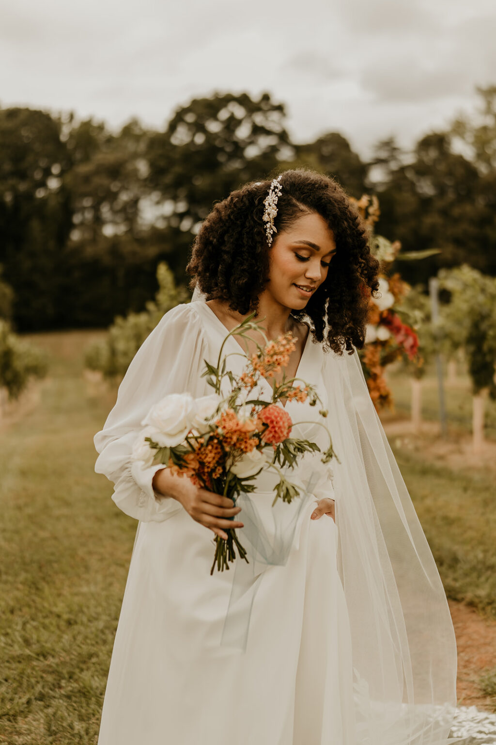 A woman holding flowers in her hand and wearing a veil.