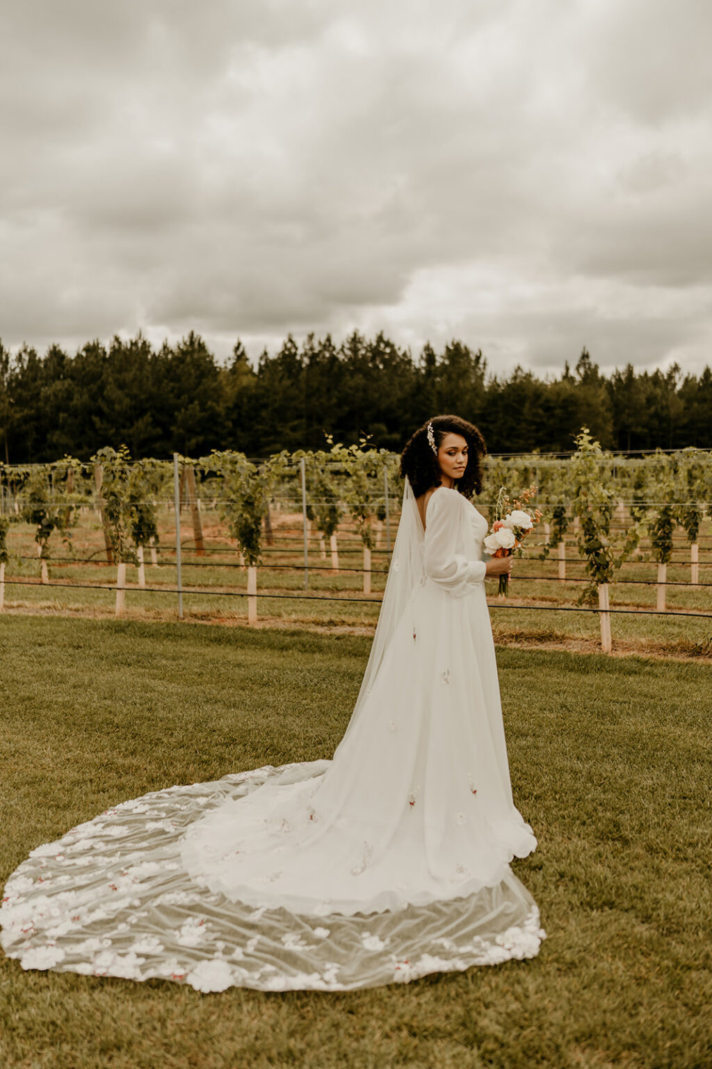 A woman in a white dress standing on top of grass.