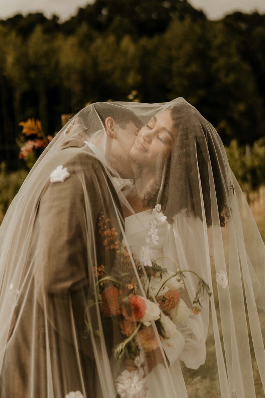 A man and woman kissing under the veil.