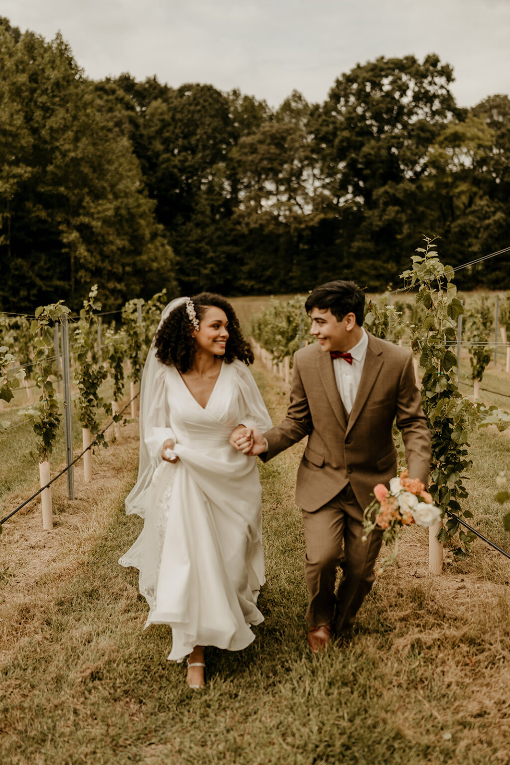 A man and woman walking through the vines