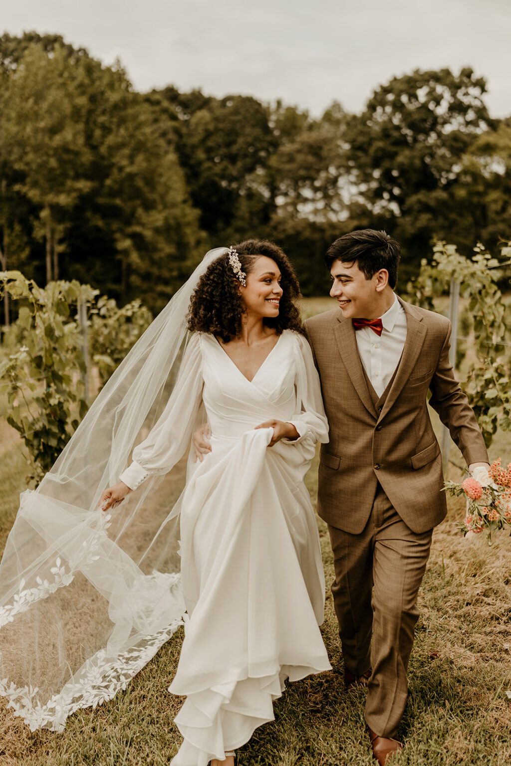 A man and woman walking through the woods together.