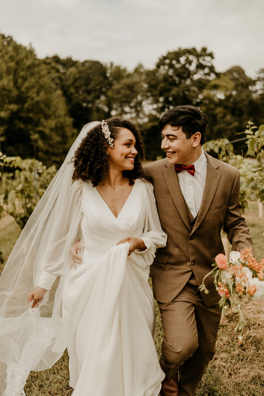 A man and woman walking through the woods together.