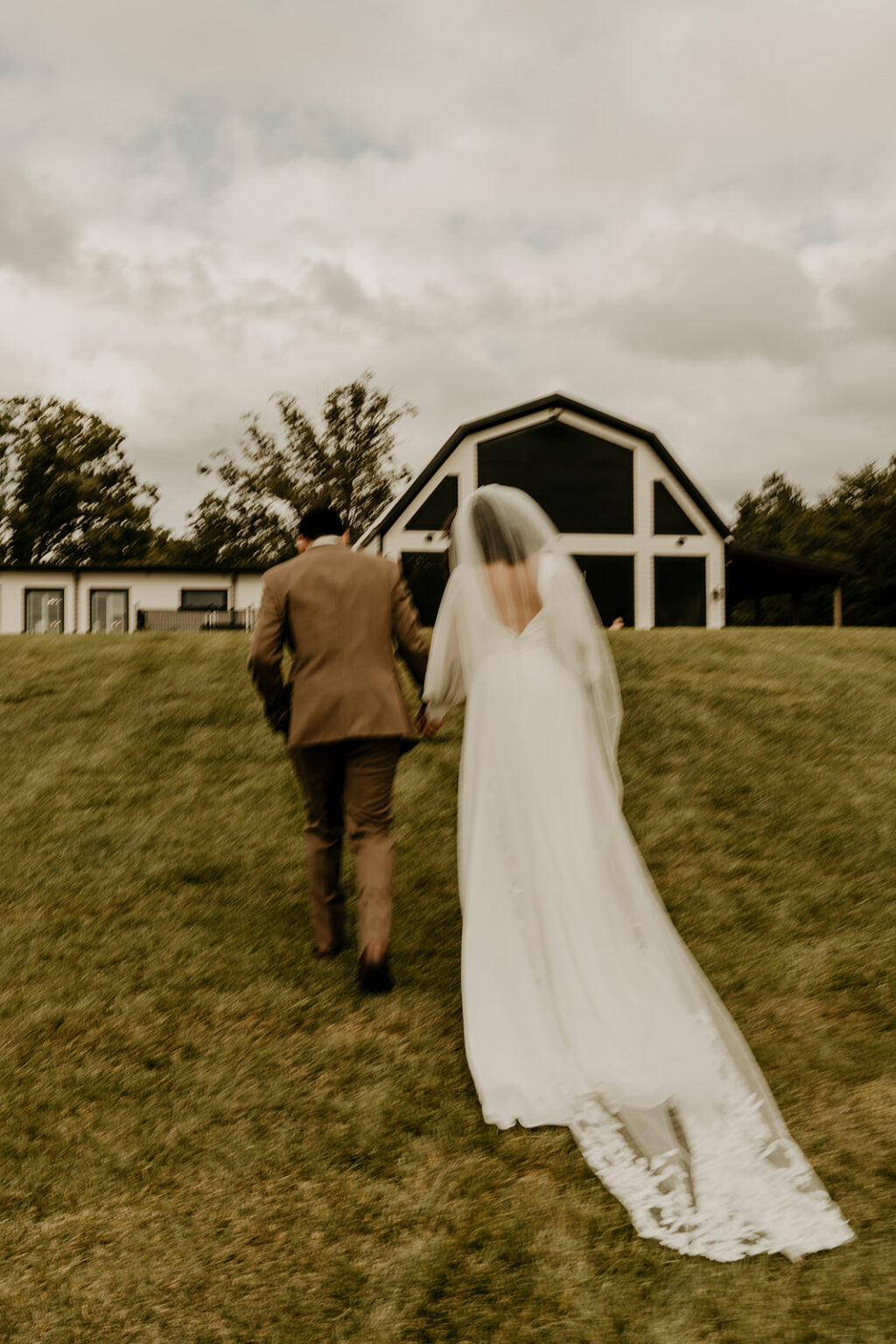 A man and woman walking in the grass.