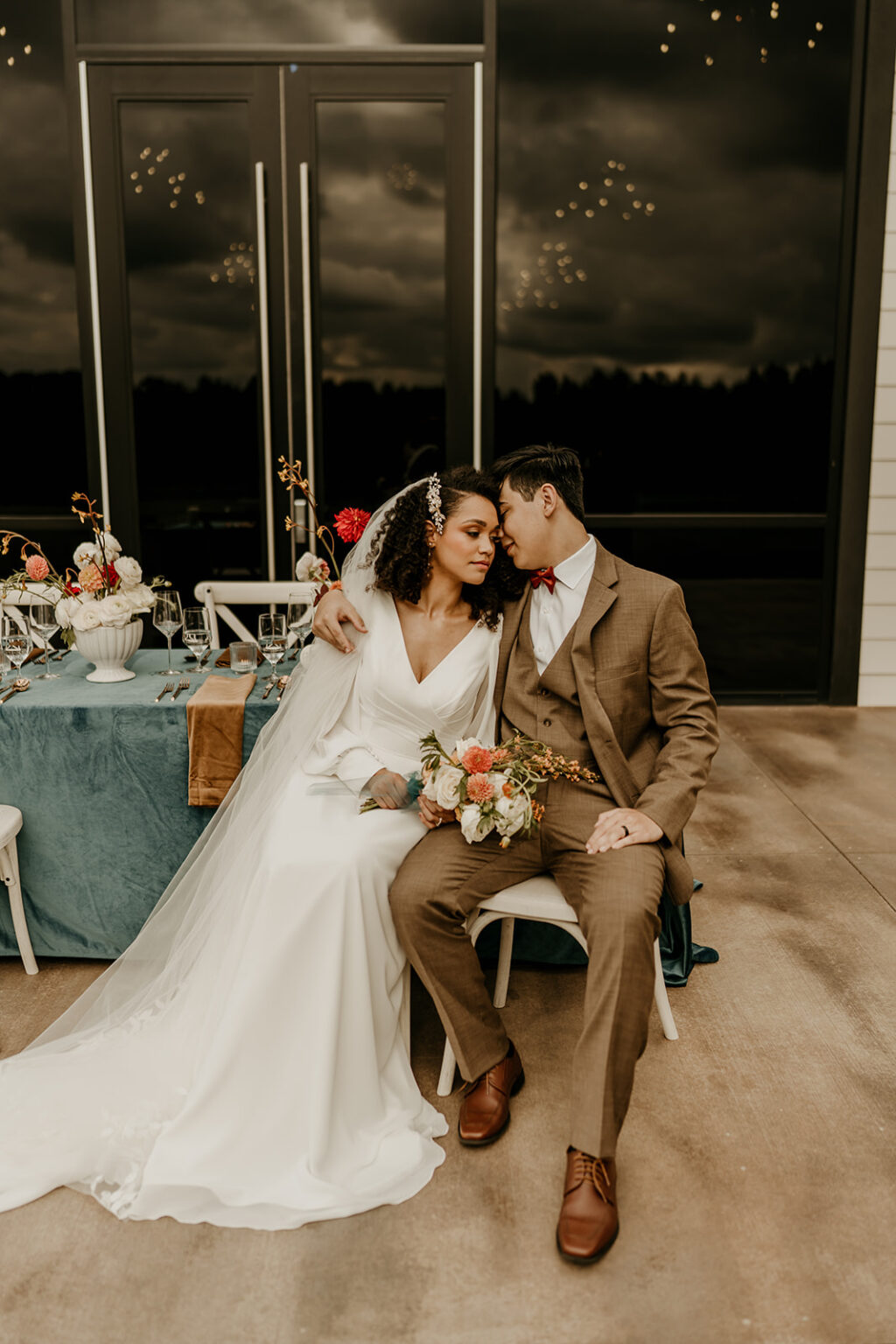 A bride and groom sitting on the ground