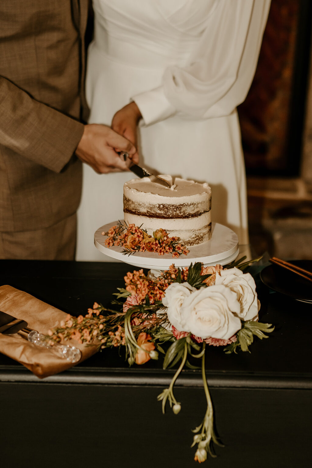 A couple cutting their wedding cake together.