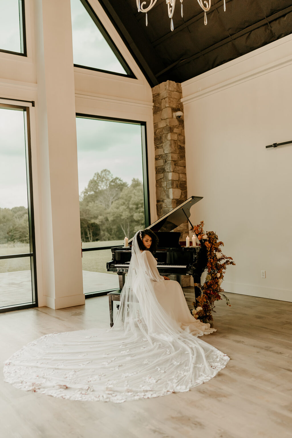 A bride and groom pose in front of a piano.