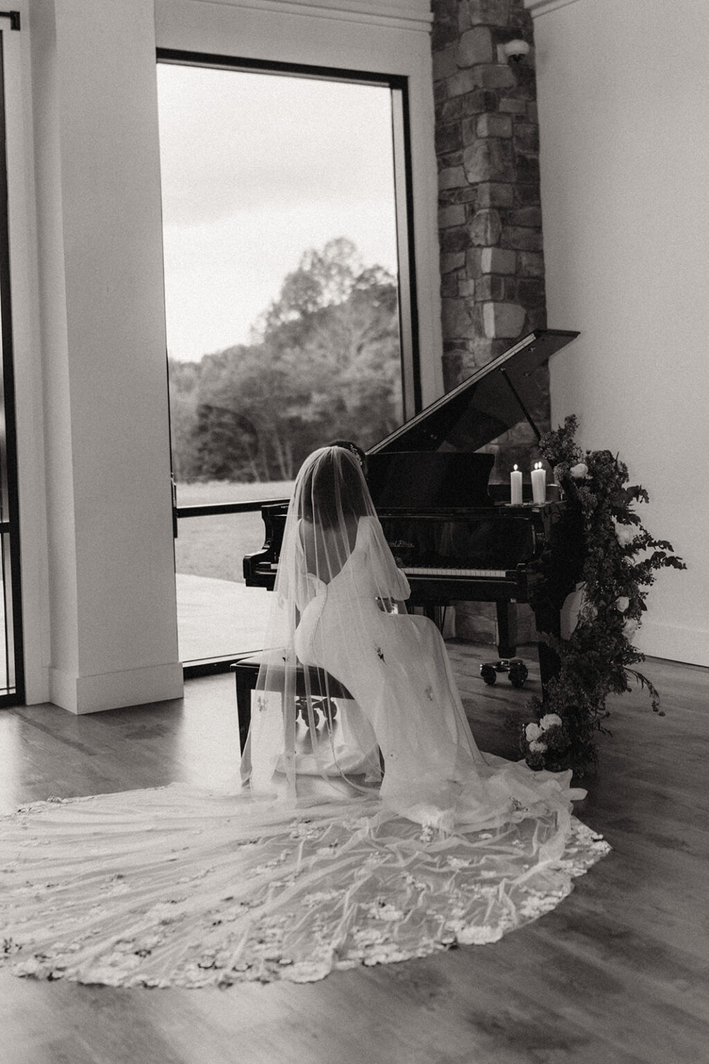 A young girl in a white dress sitting on the floor near a piano.