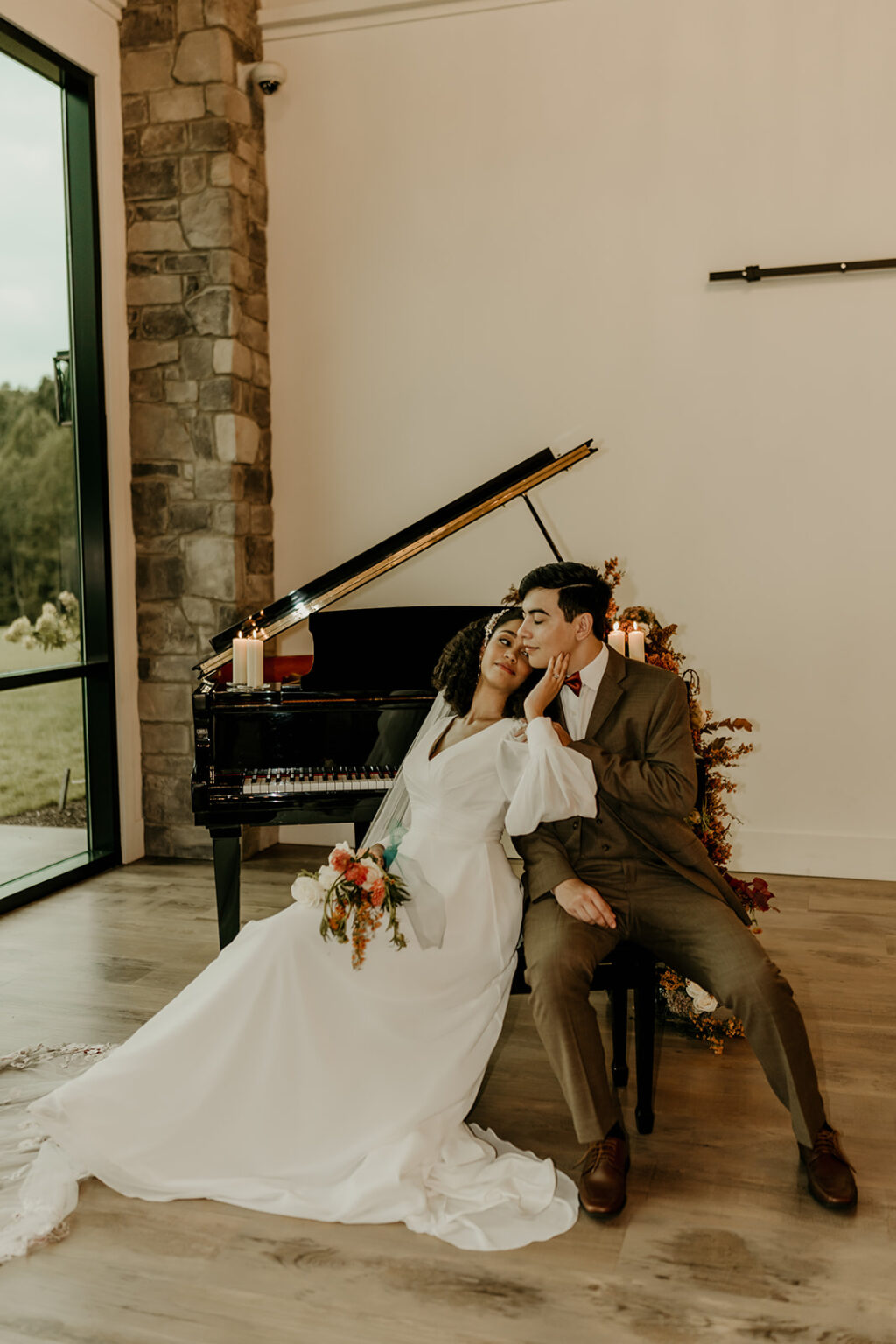 A bride and groom sitting in front of a piano.