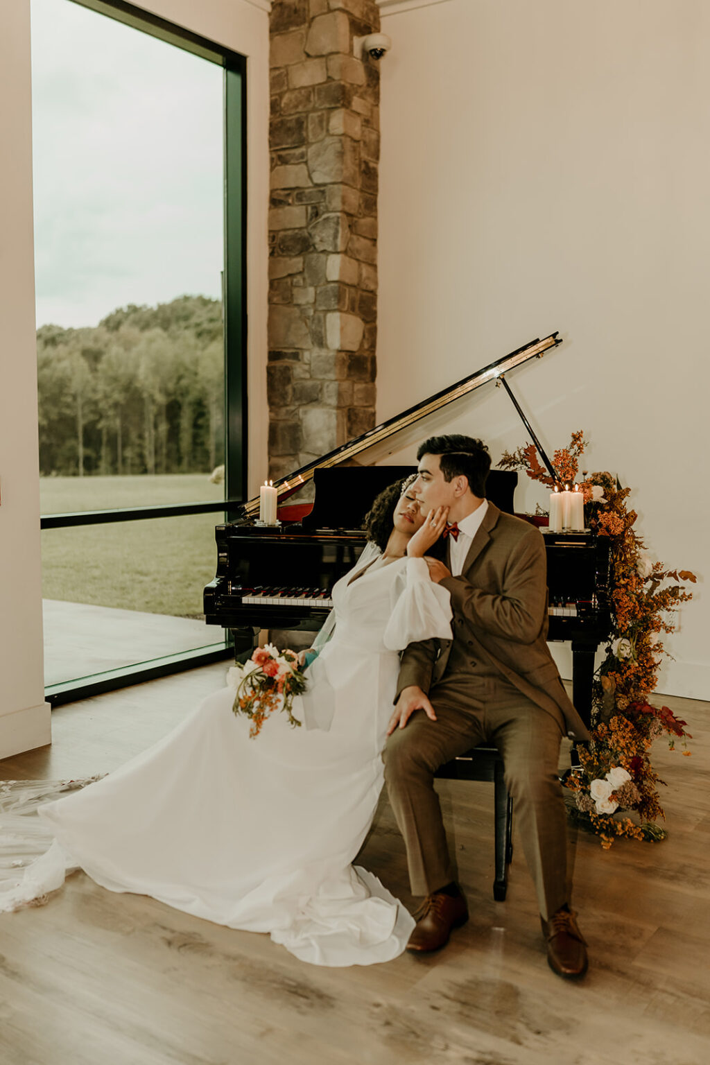 A bride and groom sitting in front of a piano.