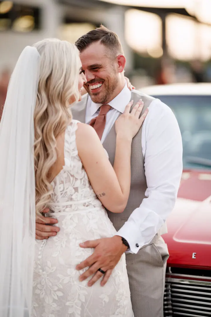 A bride and groom embracing on the street.