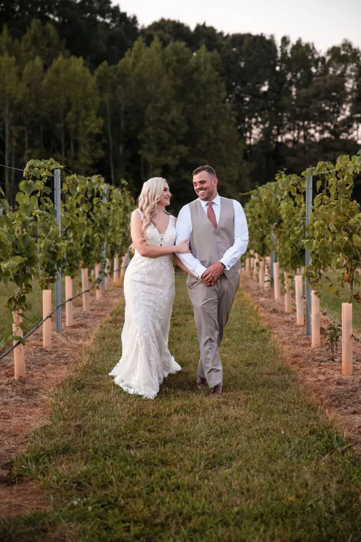 A man and woman walking through the grass.