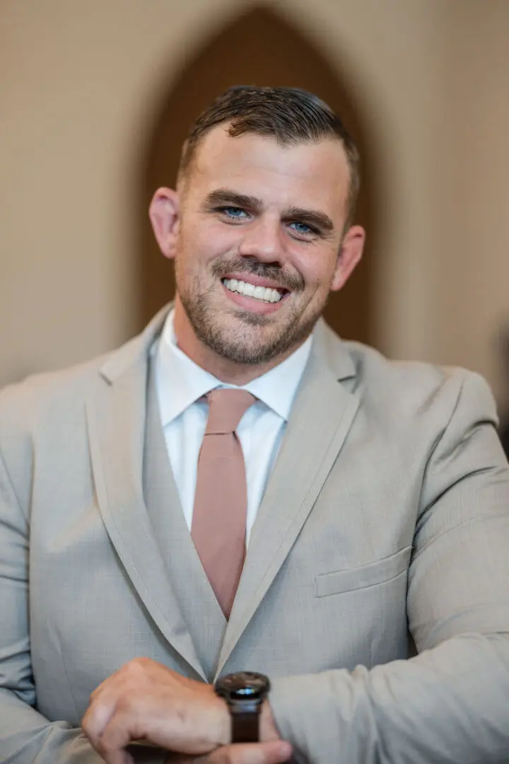 A man in suit and tie smiling for the camera.