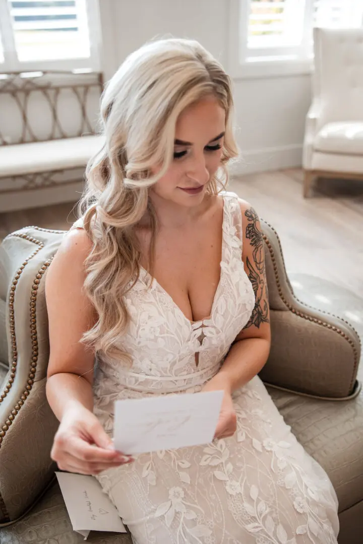 A woman in white dress holding a card