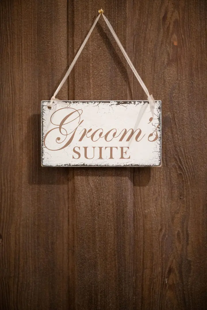 A sign hanging on the wall of a groom 's suite.