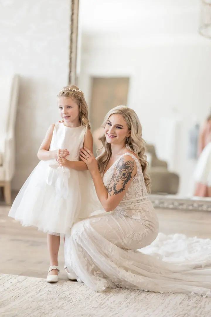 A woman and her daughter in white dresses.