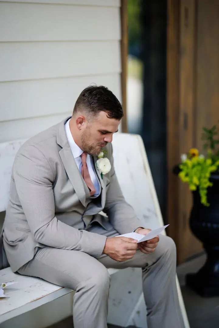 A man in suit and tie sitting on the ground