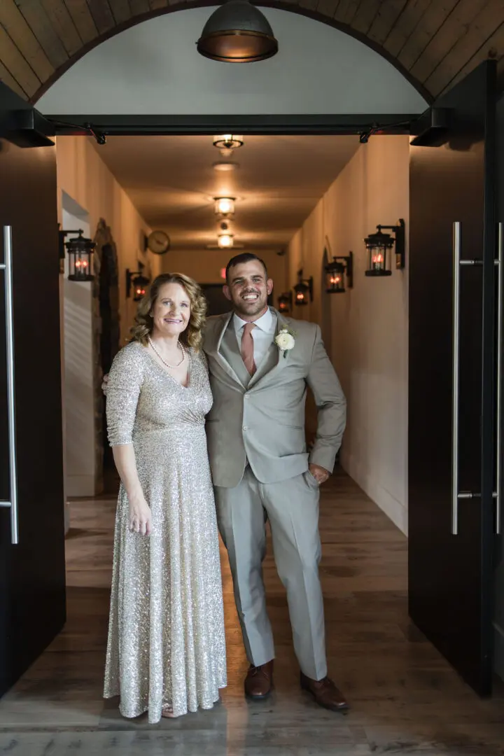 A man and woman posing for a picture in front of an entrance.