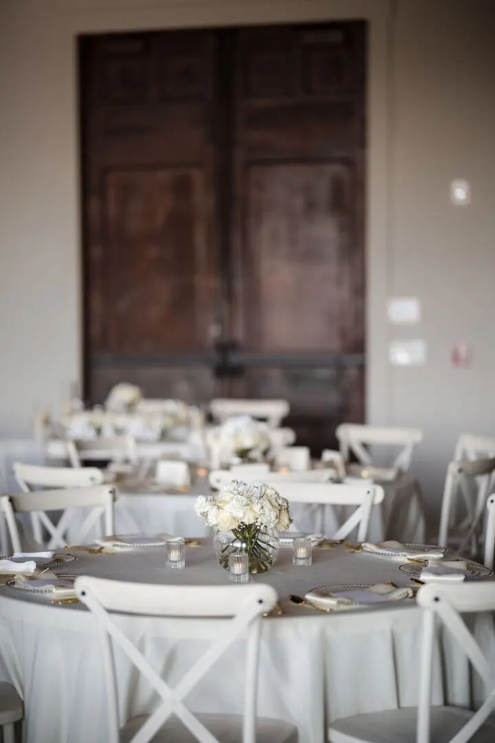 A table set up with white chairs and tables.