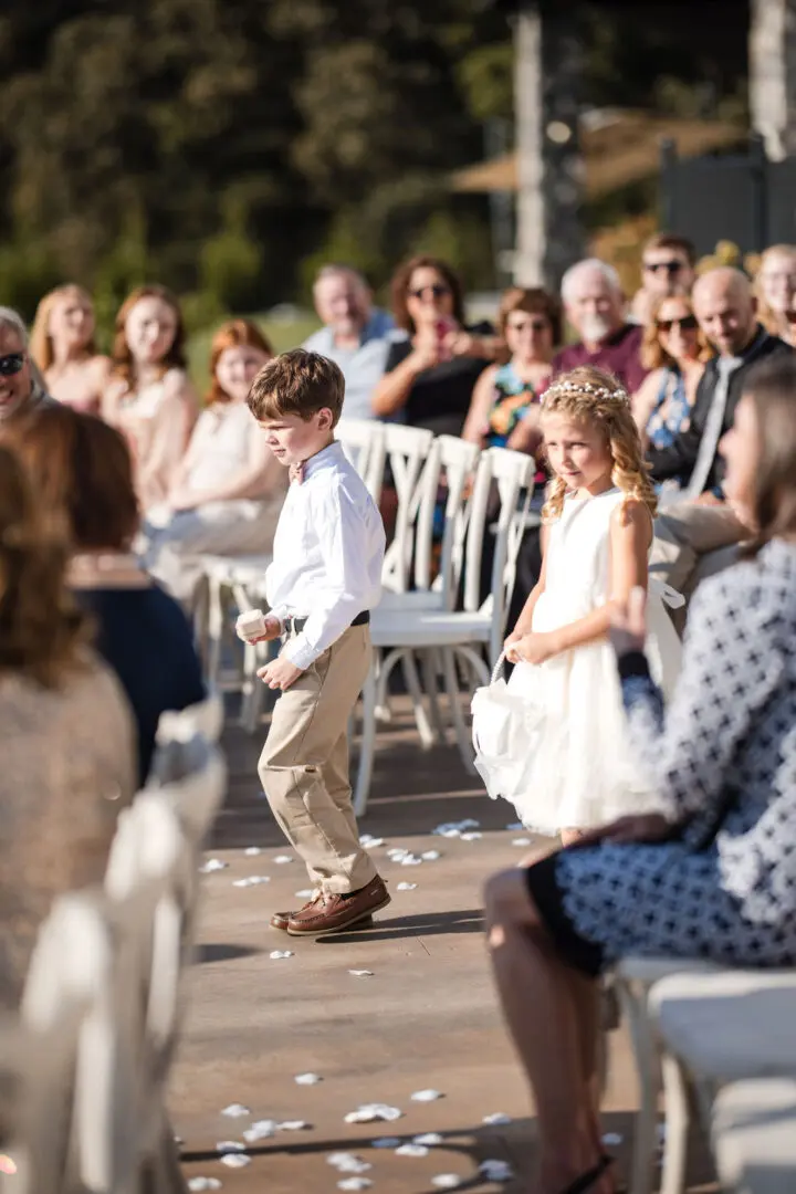 A young boy walking down the aisle at a wedding.