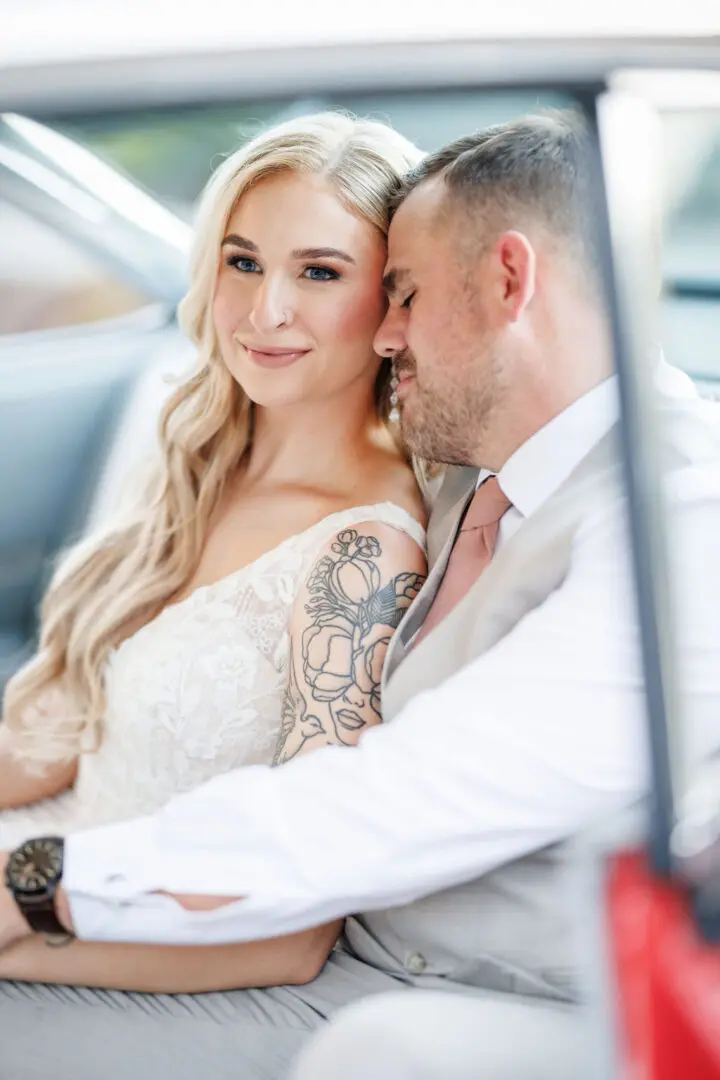 A man and woman sitting in the back of a car.