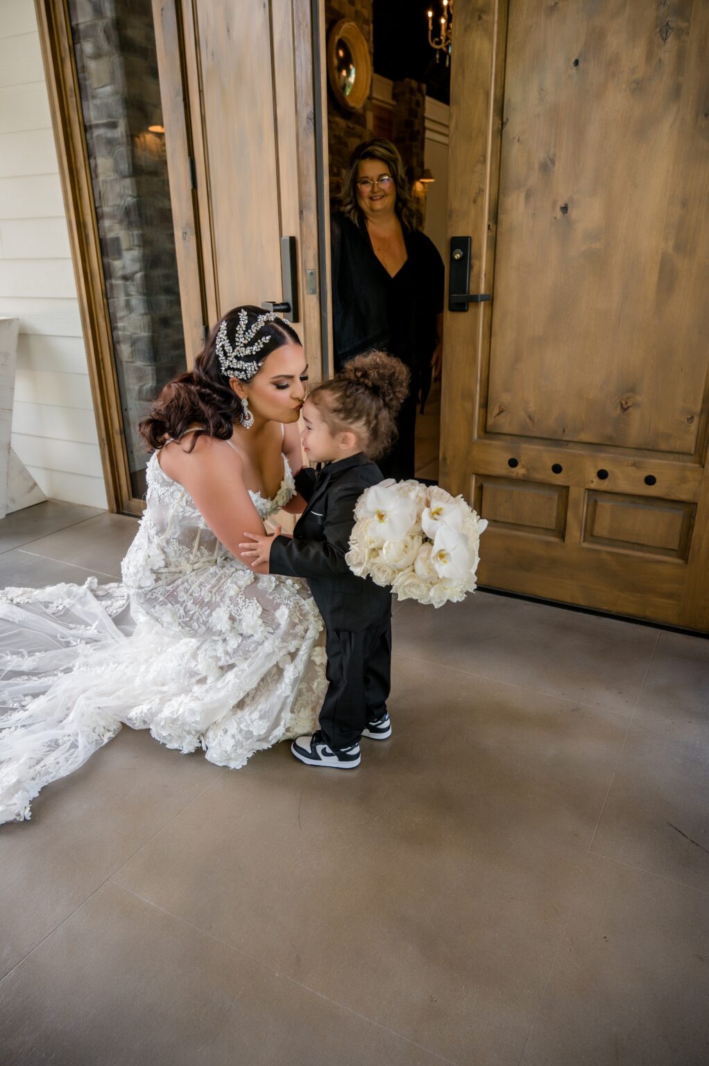 A woman in a wedding dress holding onto a little boy