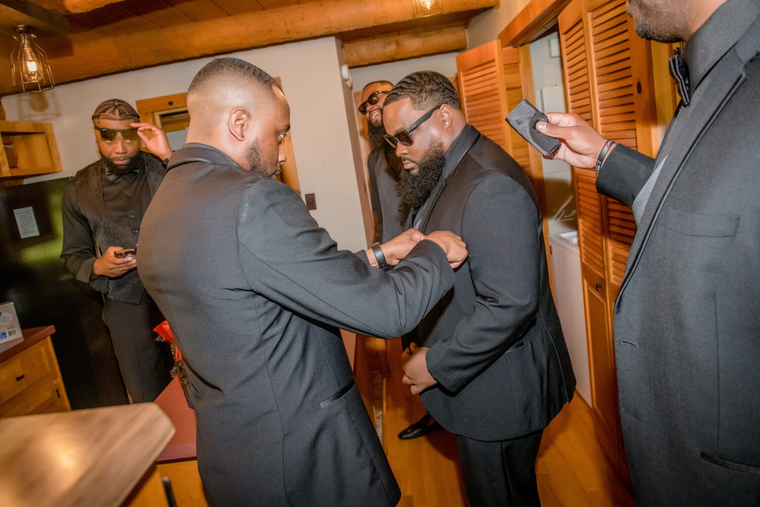 A man in a suit and tie fixing another mans tie.