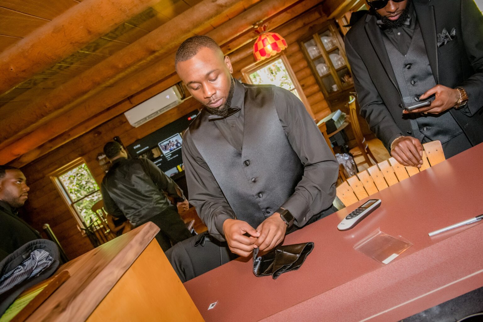 A man in a gray suit is looking at his phone.