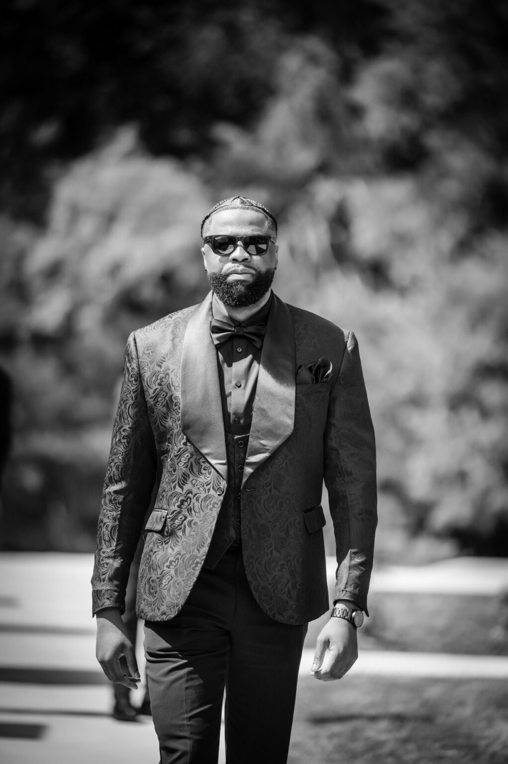 A man in suit and tie standing outside.