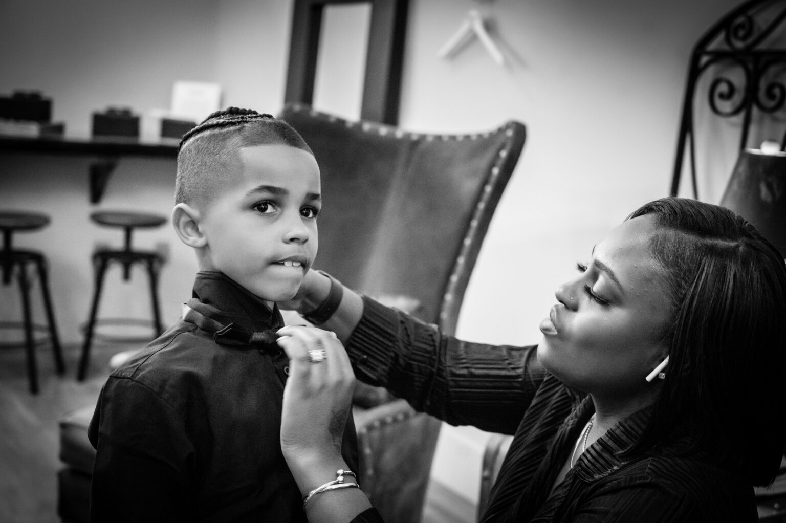 A woman helping a boy with his hair.