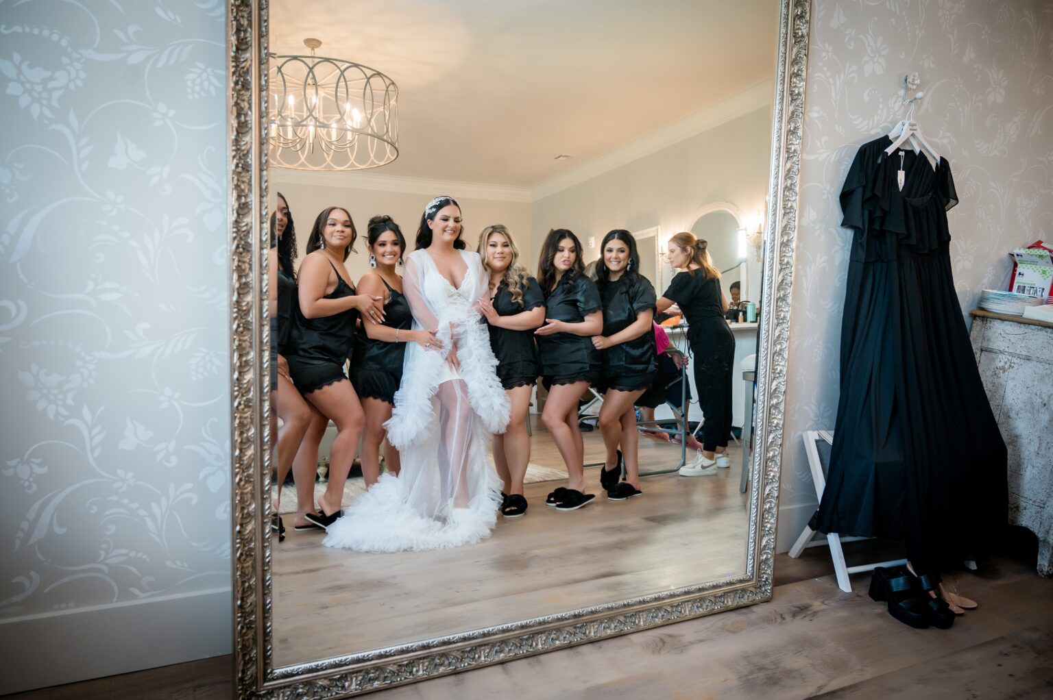 A group of women standing in front of a mirror.