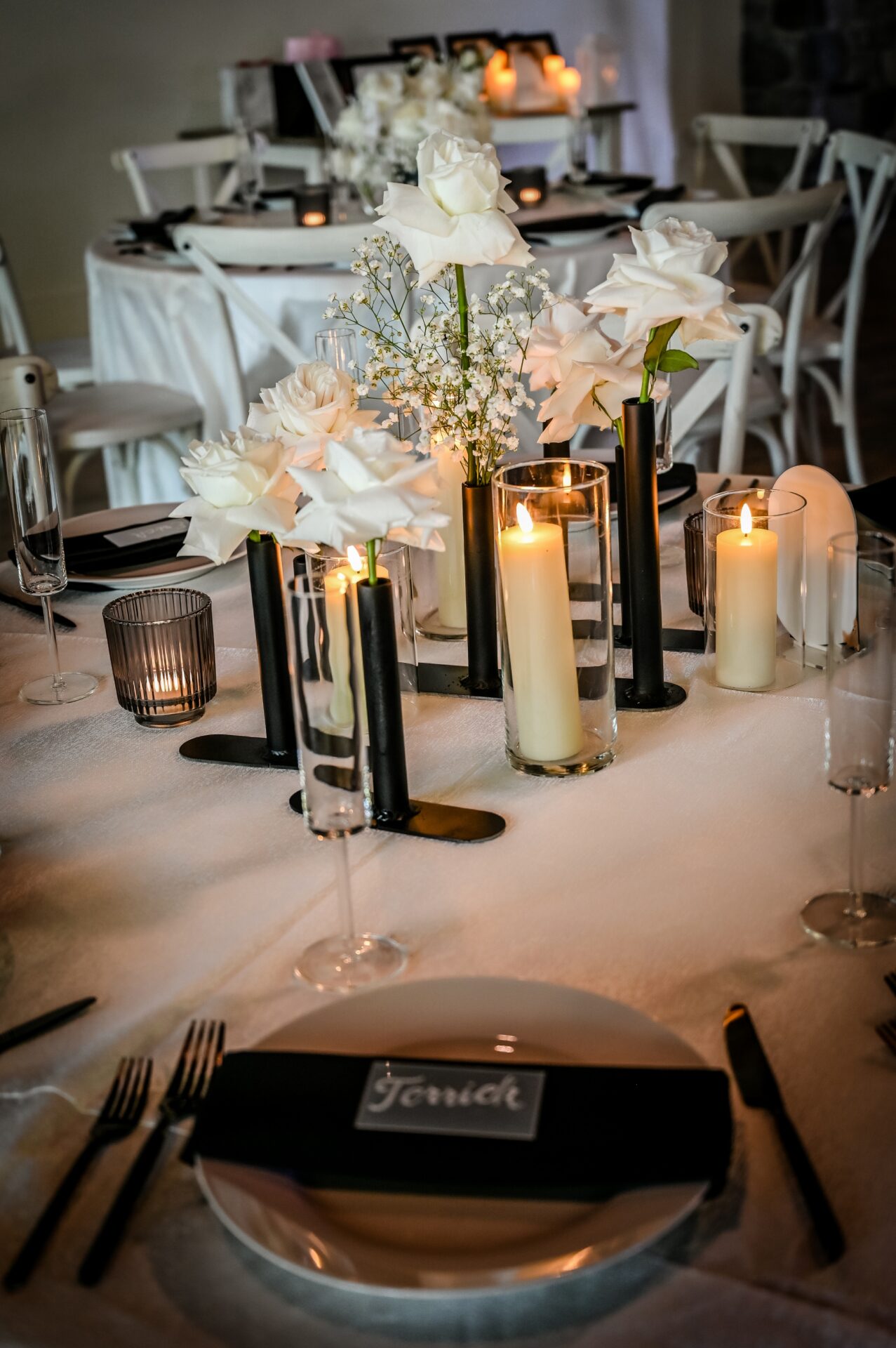 A table set with candles and flowers on top of it.