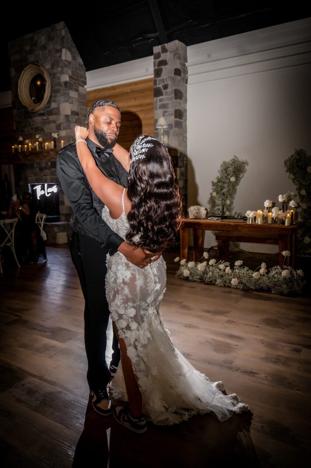 A man and woman dancing in front of candles.