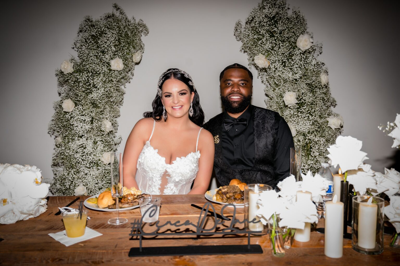 A couple sitting at the table with food.