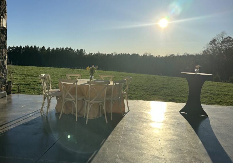 A table and chairs on the patio of an outdoor venue.